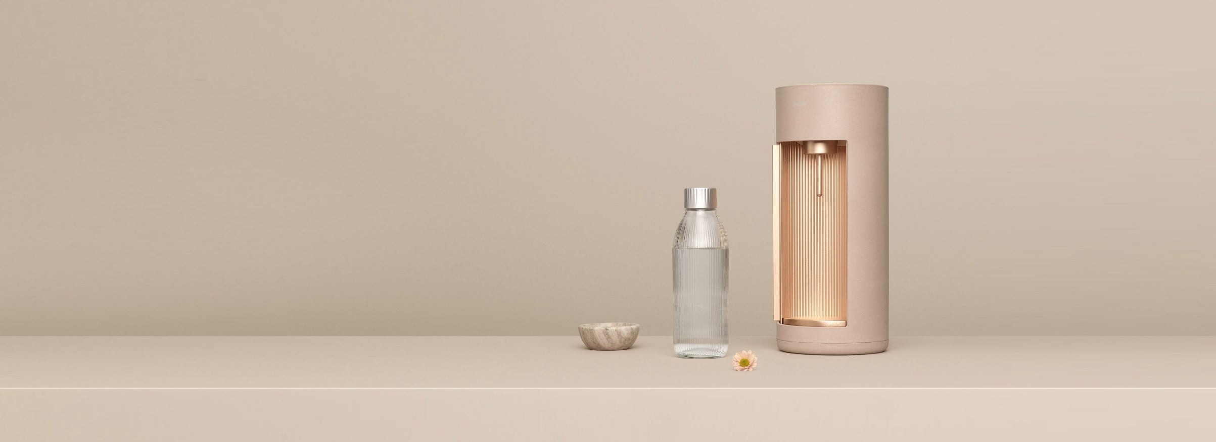 A pink Ruby 2 sparkling water maker and props in front of pink background