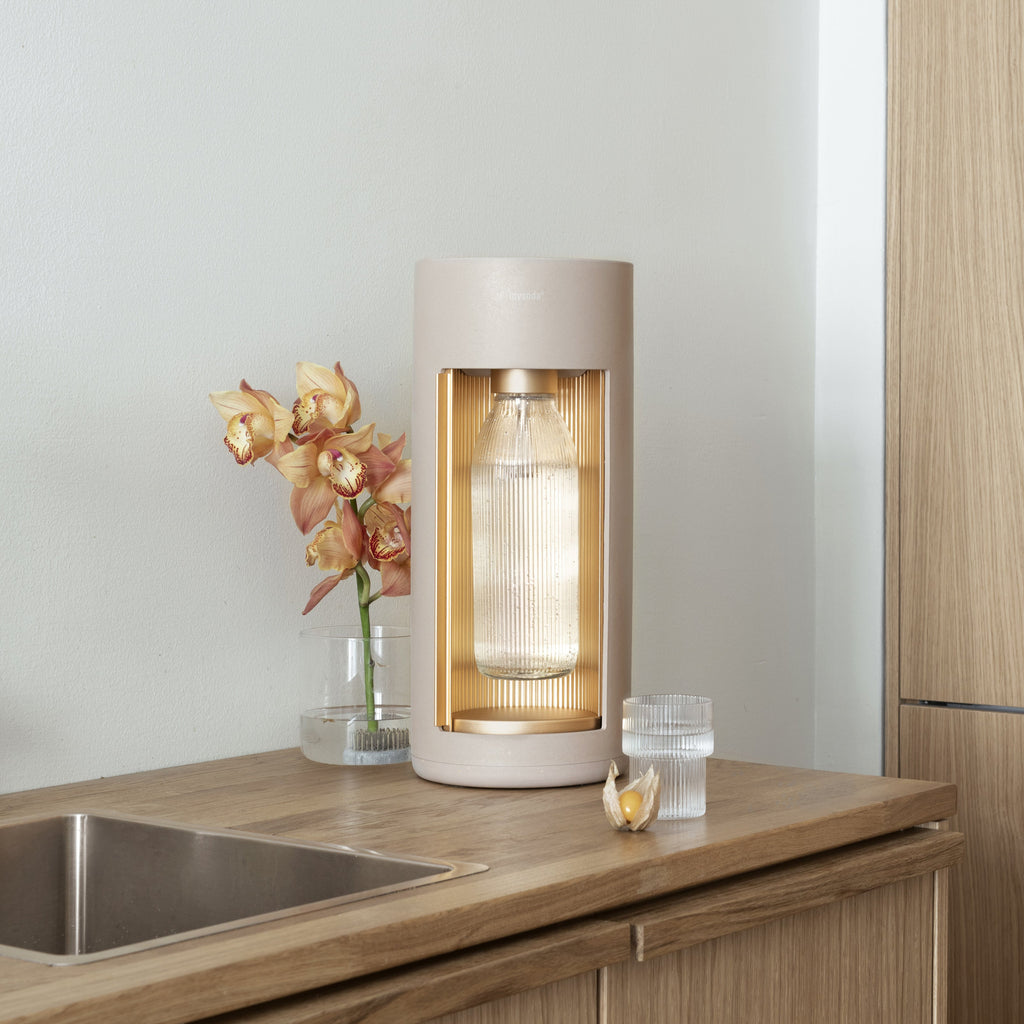 A latte Glassy sparkling water maker in a a minimalistic kitchen with wooden countertop and cupboards