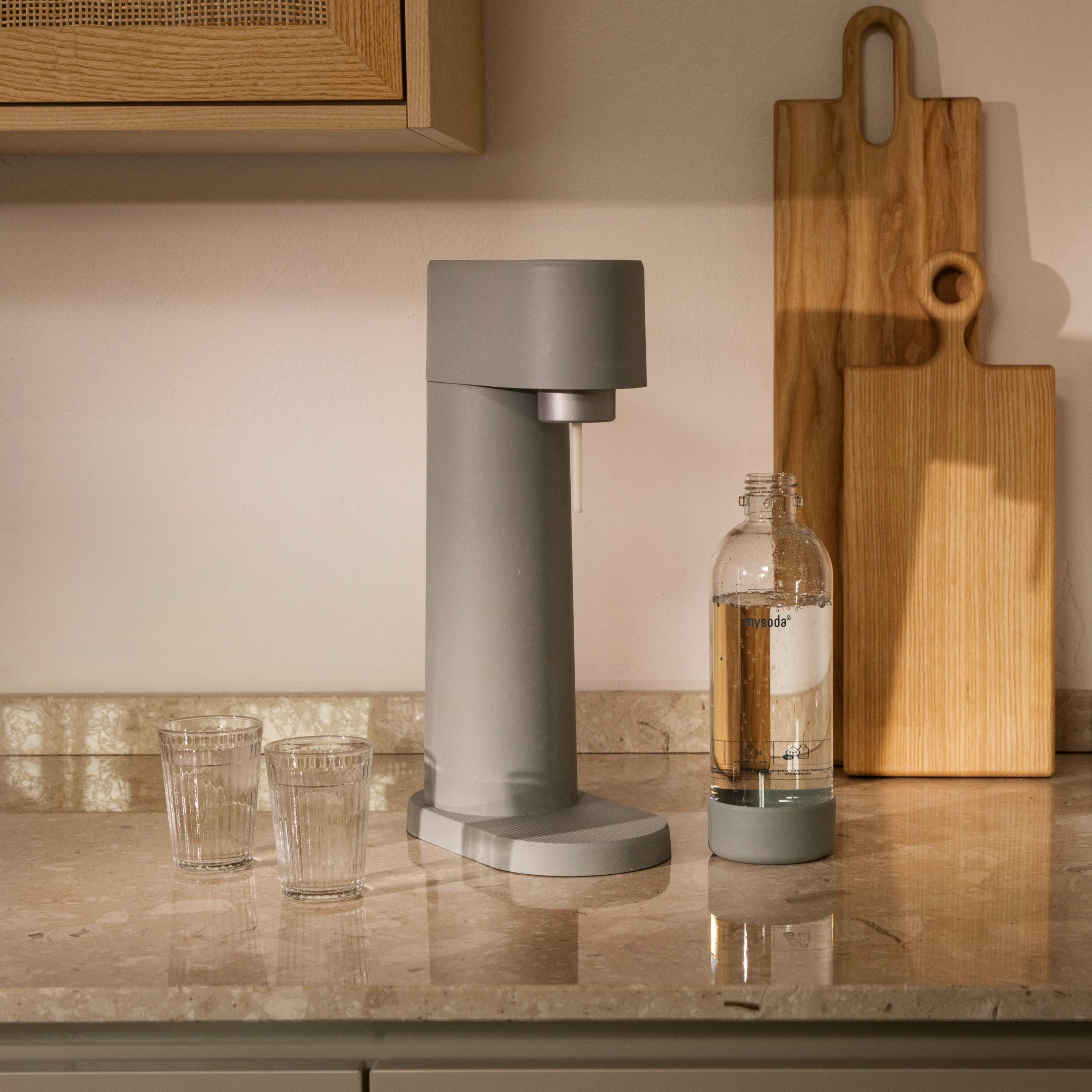 A pigeon Woody soda maker on a marble kitchen counter in warm lighting