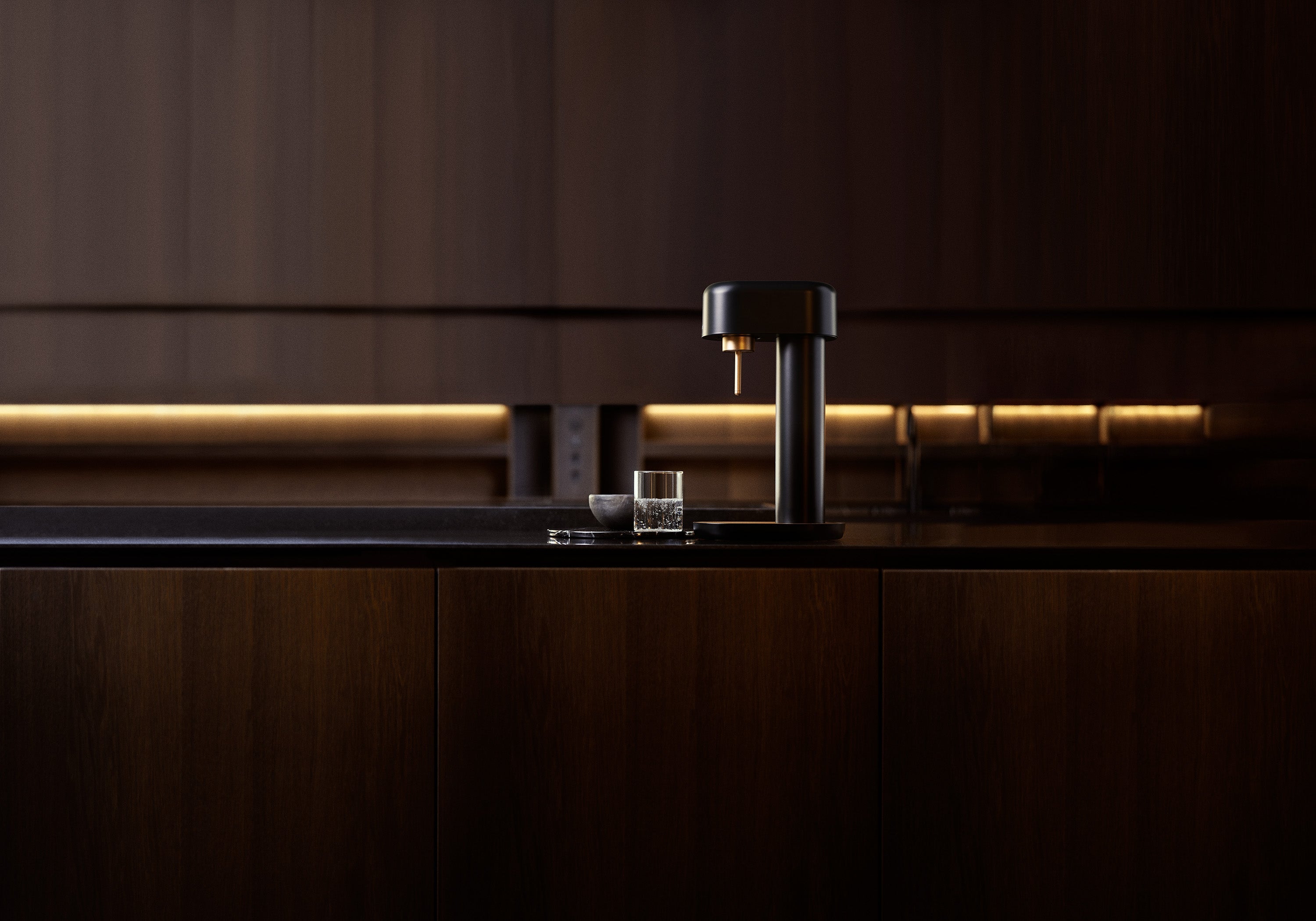 A black-copper Ruby 2 sparkling water maker in a dark kitchen with soft warm lighting in the back