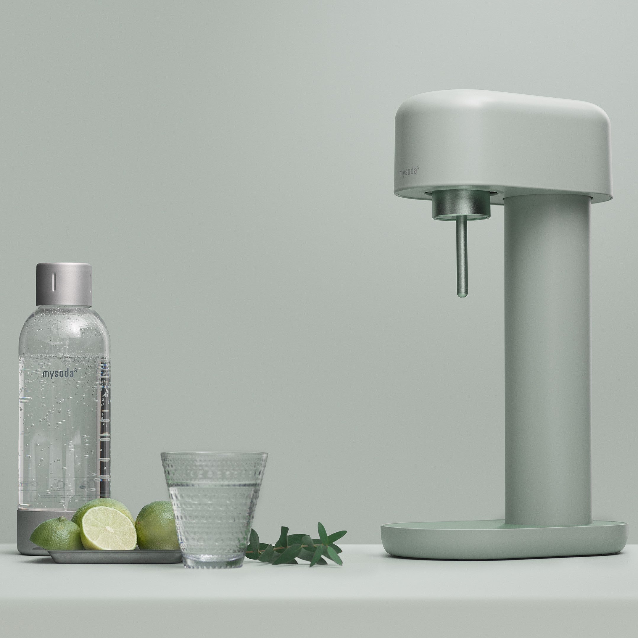 A pigeon Ruby 2 sparkling water maker and ater bottle in a matching green studio setting